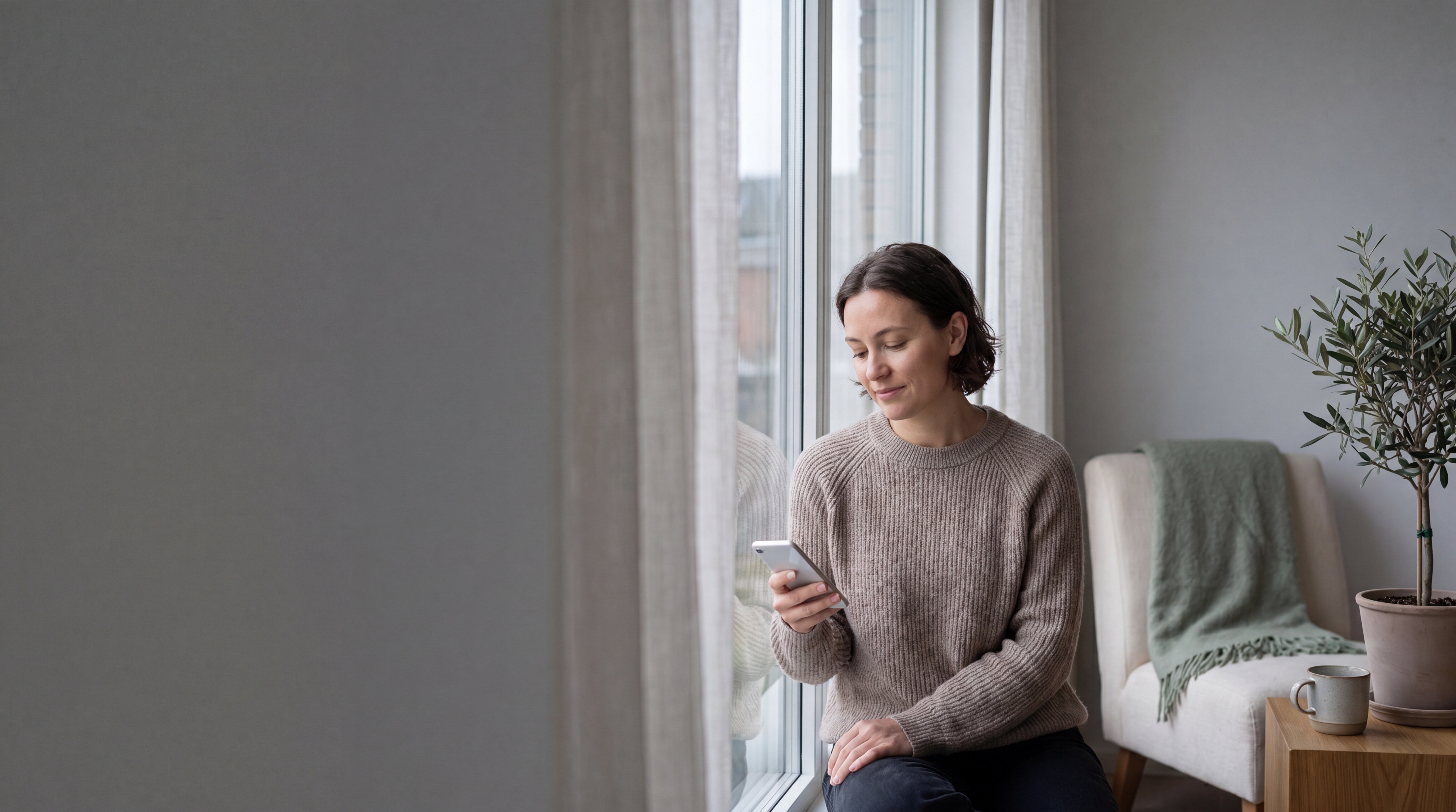 Une personne assise au calme, smartphone en main, prête à parler