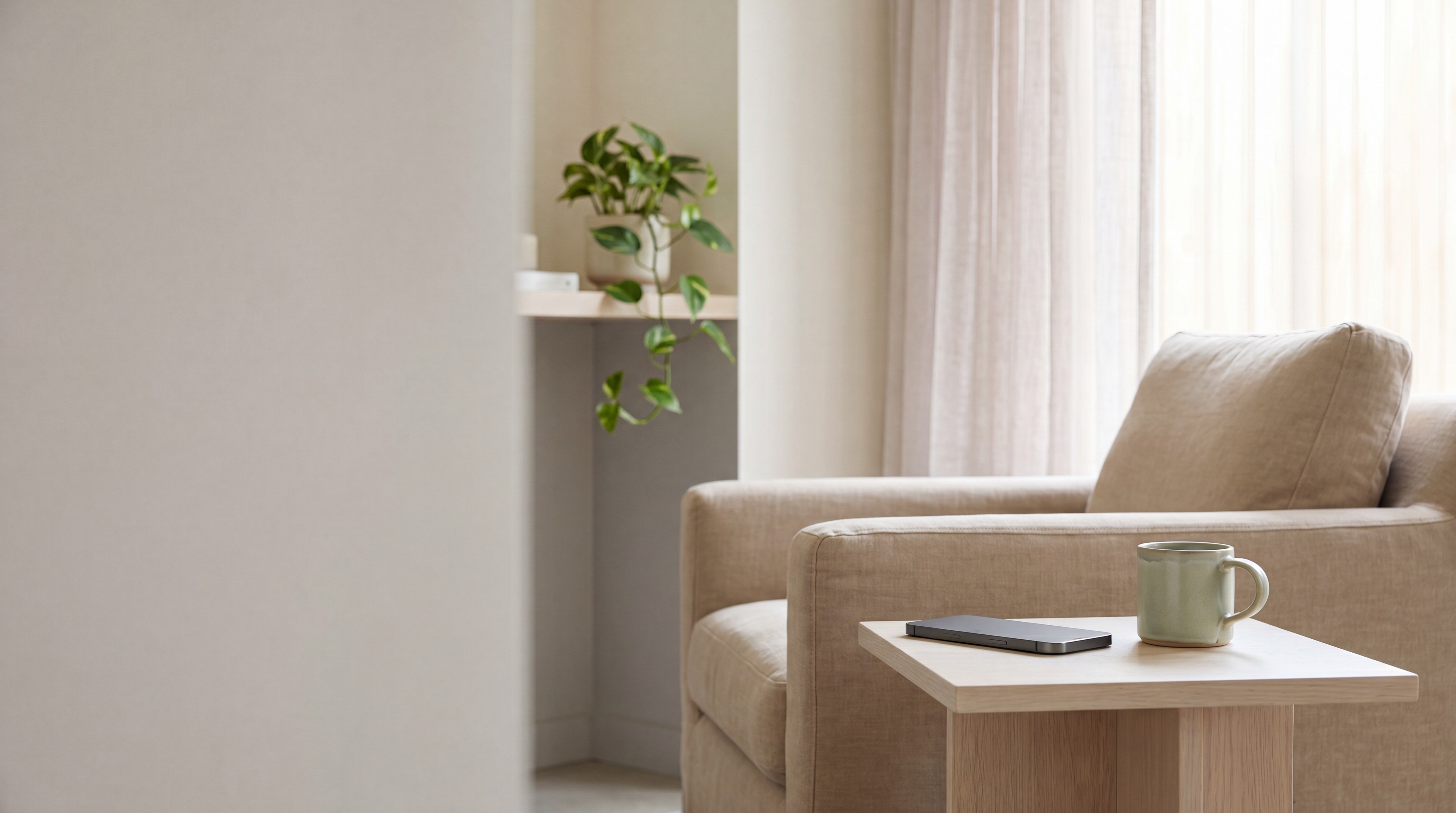 Un téléphone posé dans un intérieur calme, près d'une tasse, prêt pour une conversation confidentielle
